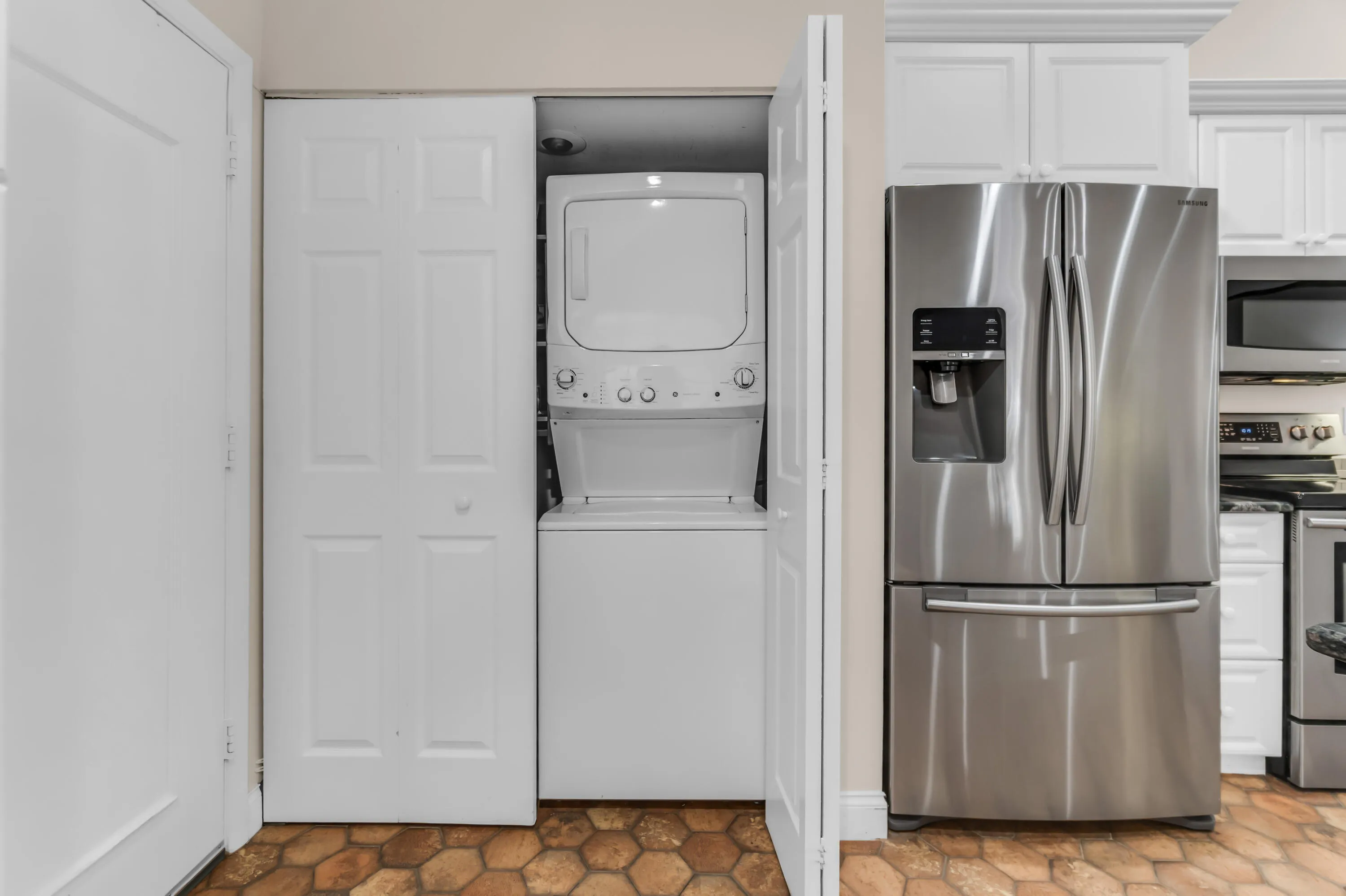 Stacked washer and dryer unit concealed by bi-fold doors