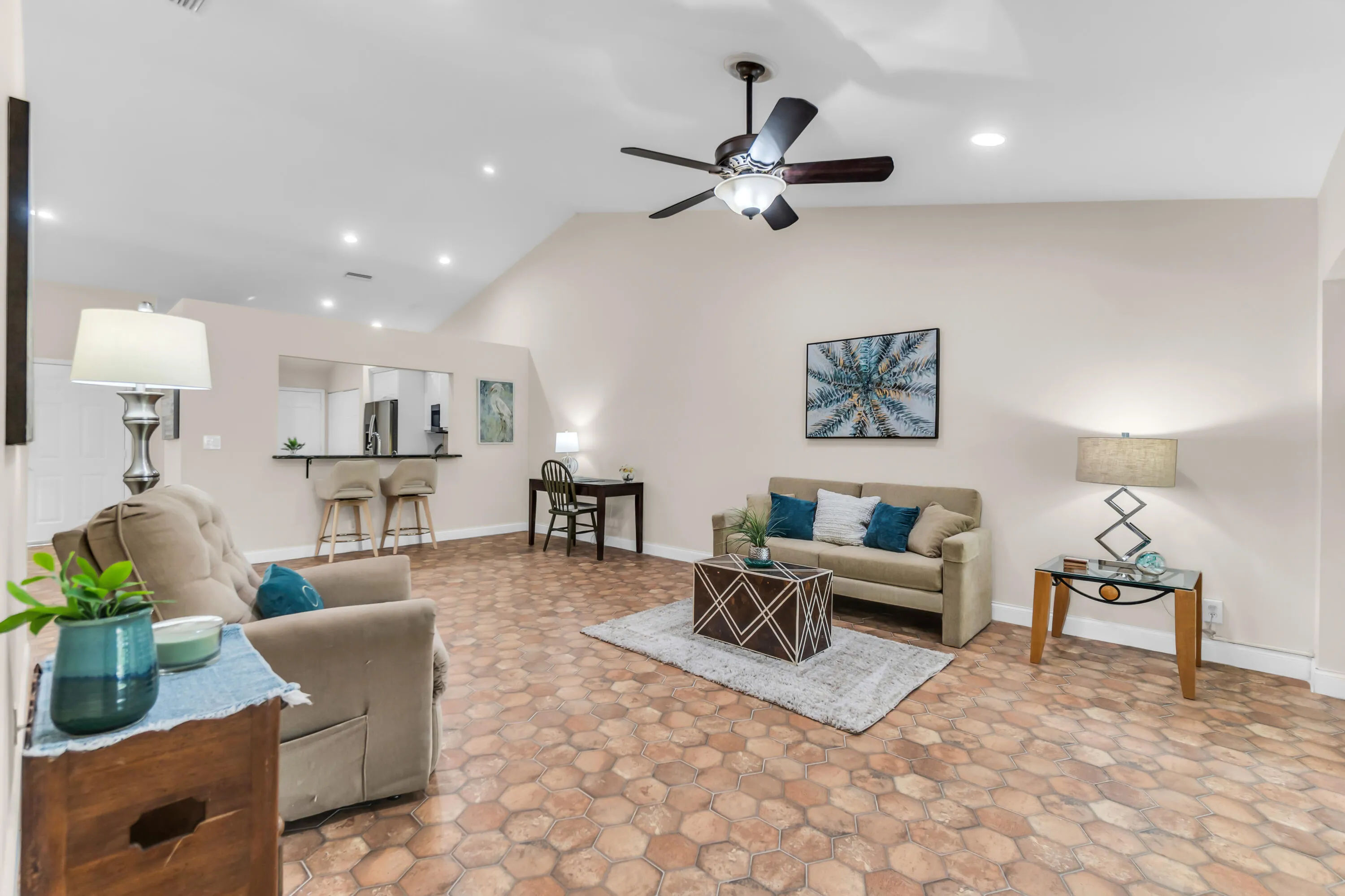Spacious living area featuring unique hexagonal tile flooring and vaulted ceilings