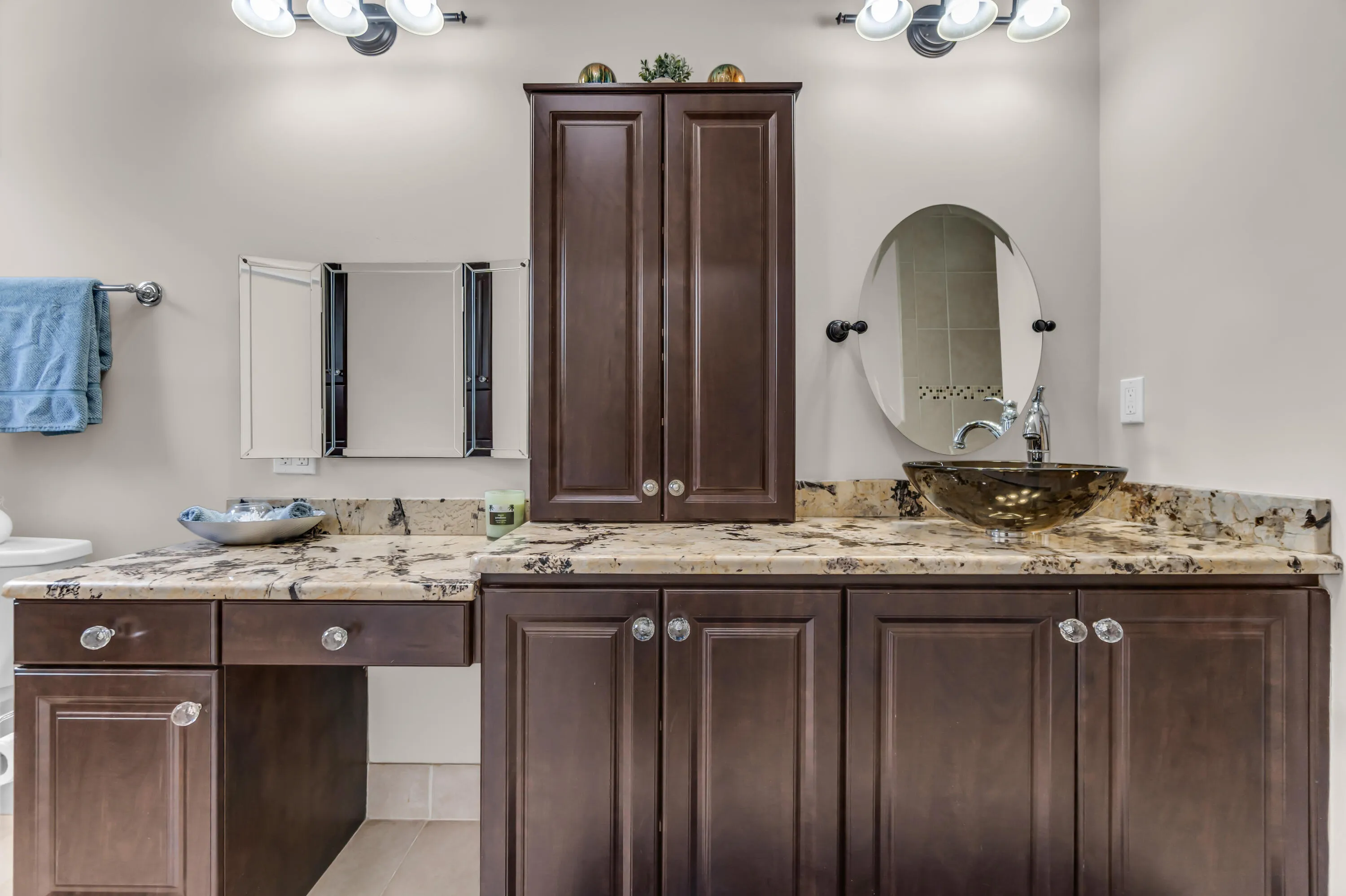 Bathroom vanity featuring dark wood-finish cabinetry, granite countertops, and a vessel sink