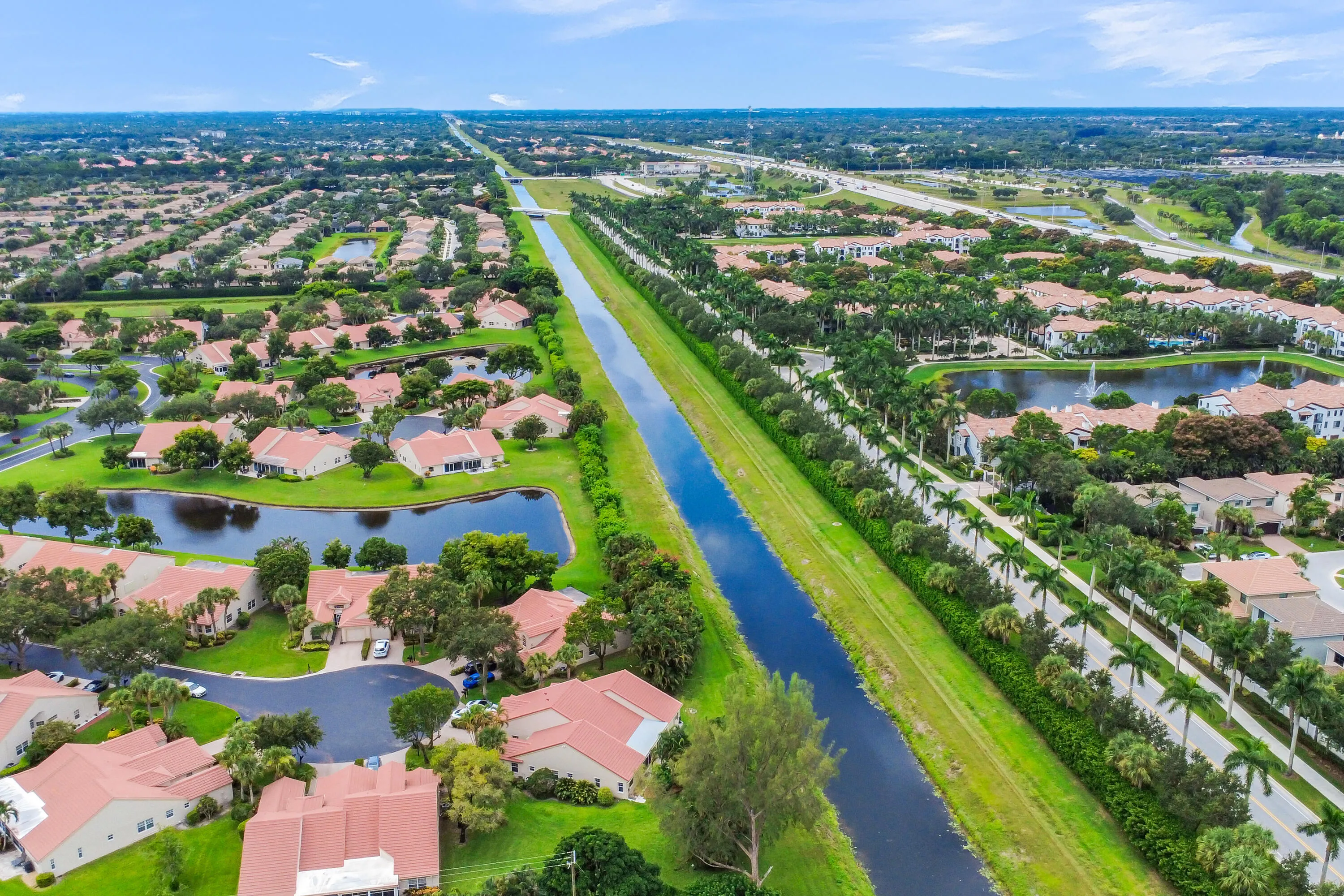 Expansive aerial perspective showcasing a residential community with numerous properties featuring terracotta-style roofing