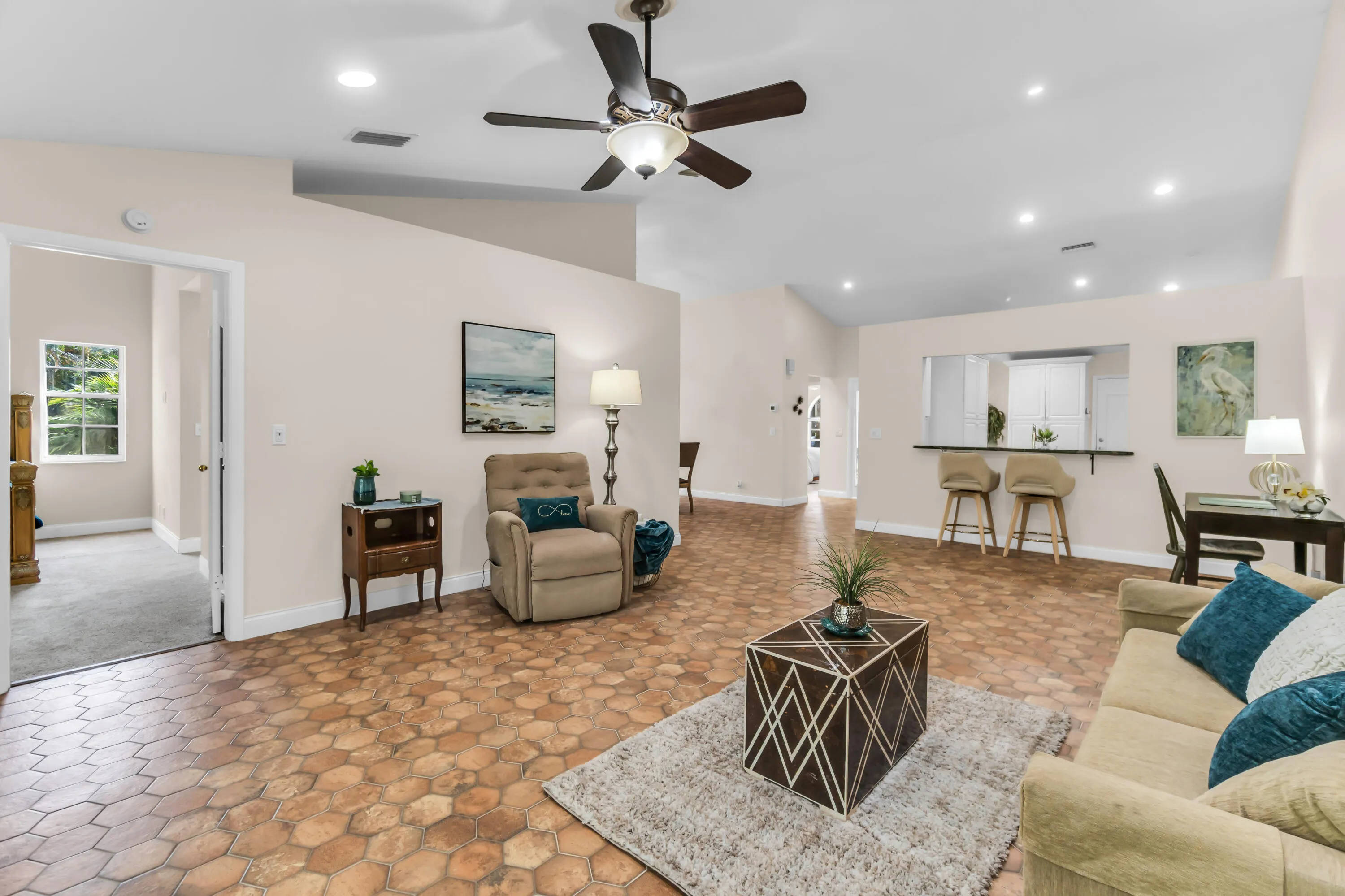 Spacious living area featuring hexagonal tile flooring, vaulted ceilings, and recessed lighting
