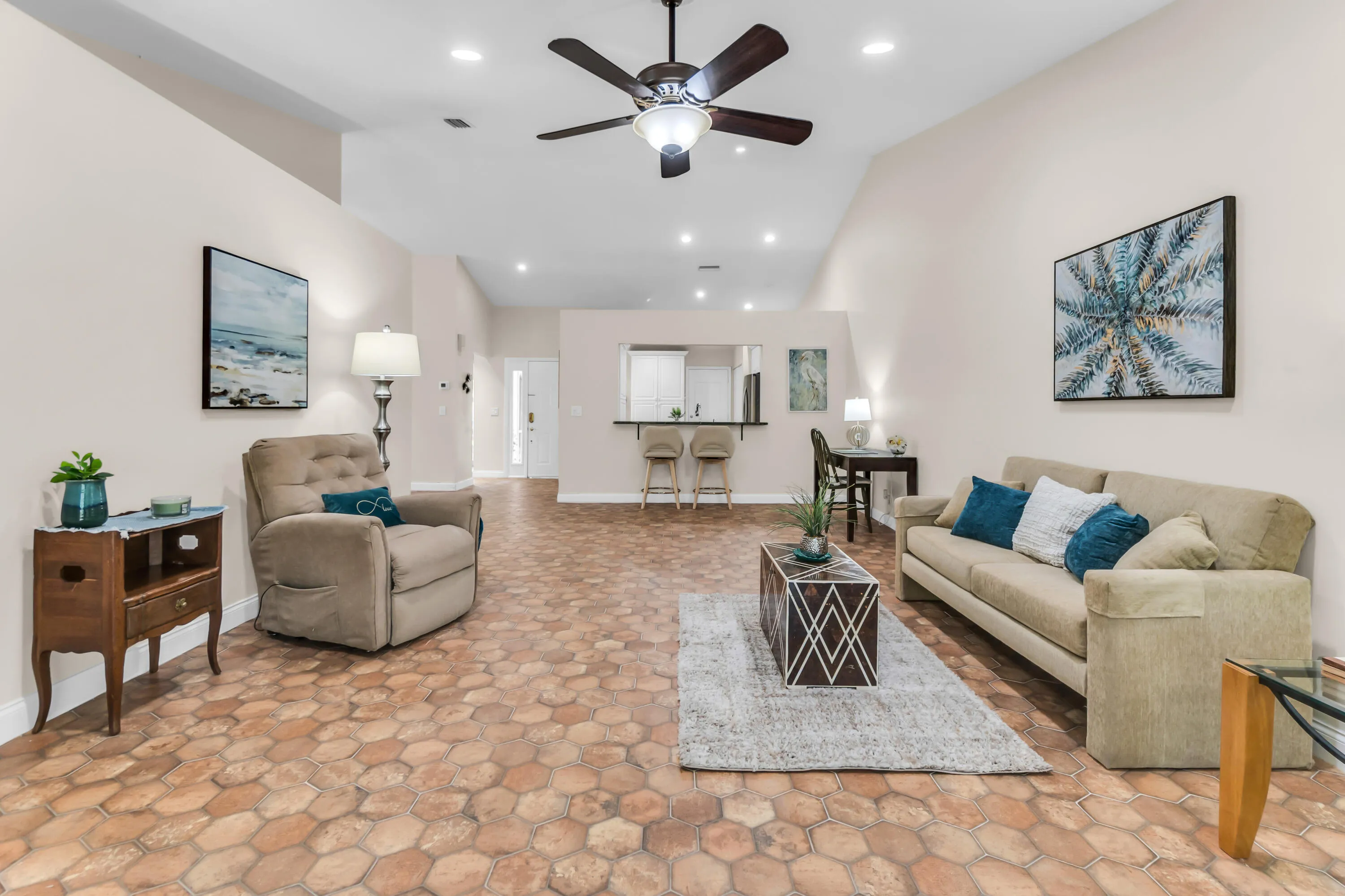 Spacious living area featuring hexagonal tile flooring, vaulted ceilings, recessed lighting, and a ceiling fan
