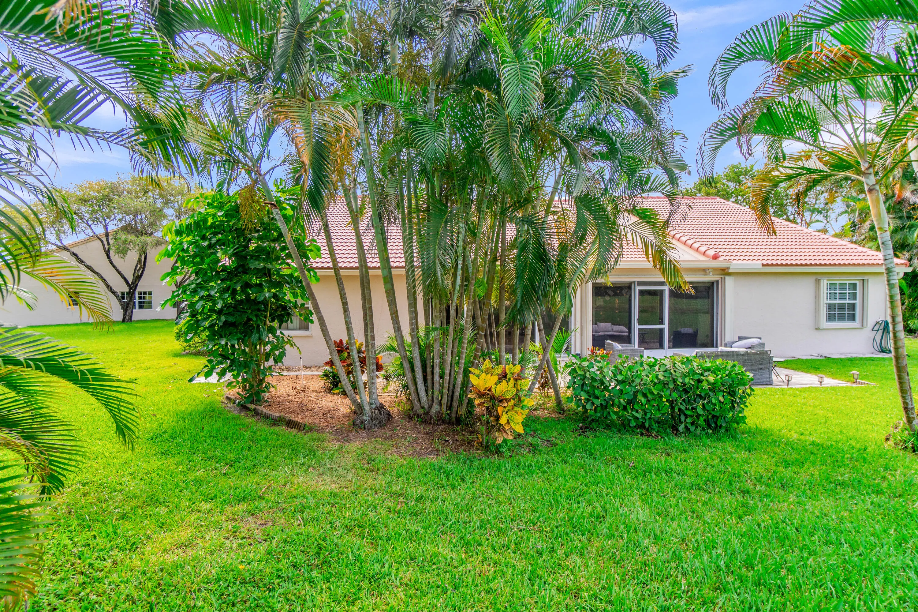 Expansive green lawn bordering a tiled patio