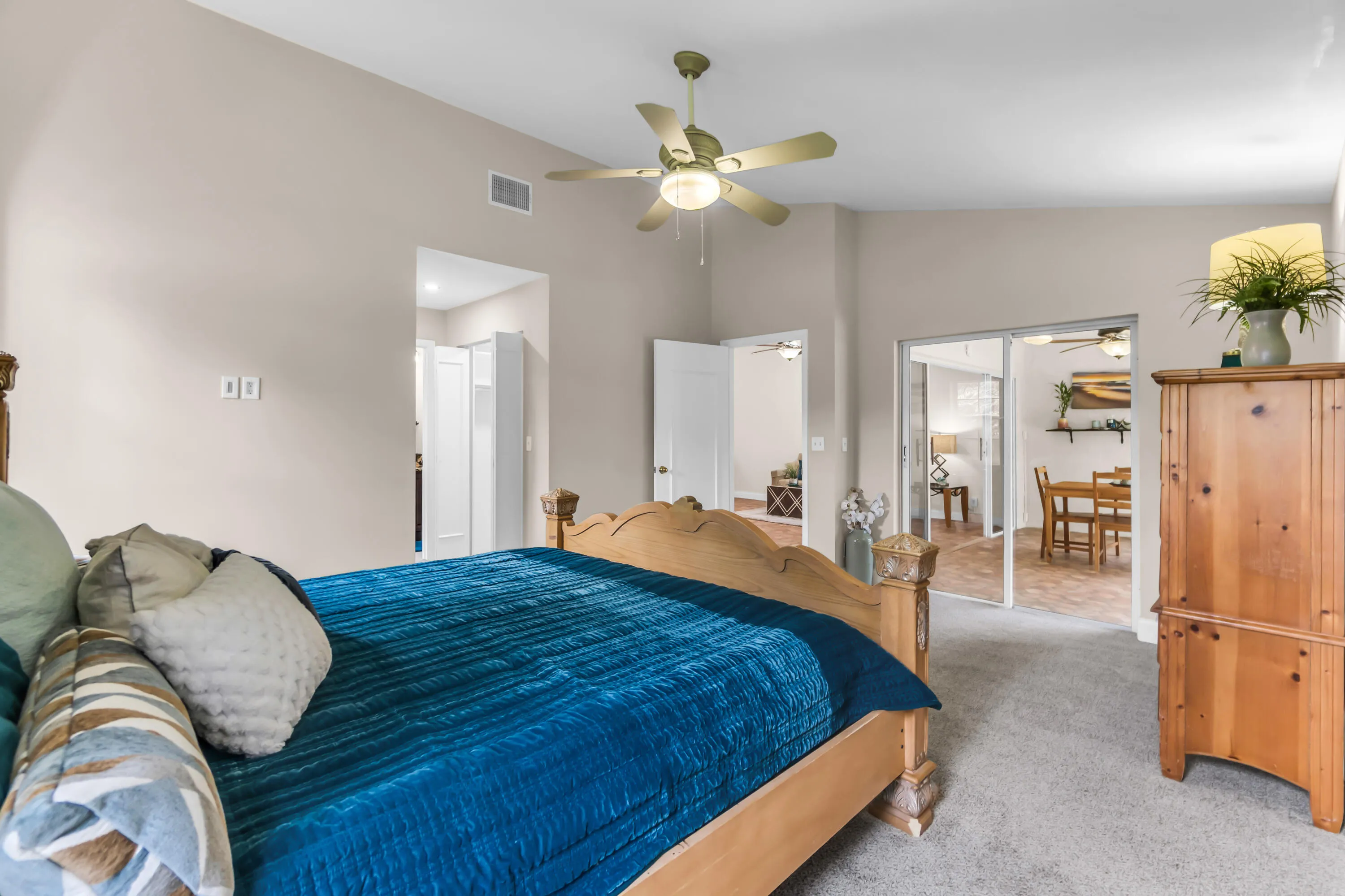 Carpeted bedroom with vaulted ceilings and a ceiling fan