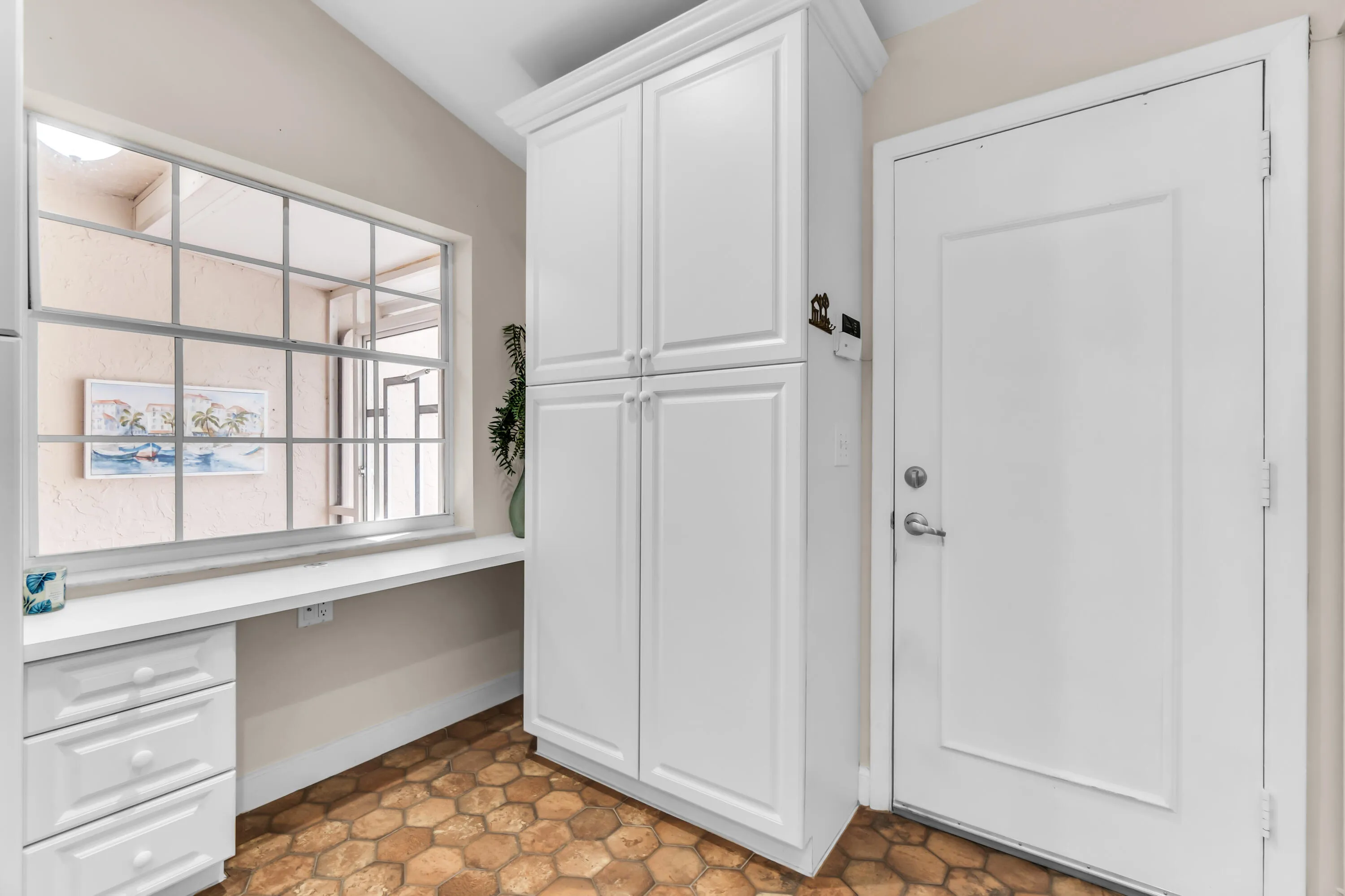 Dedicated work alcove featuring a large window, built-in desk, and three-drawer cabinet