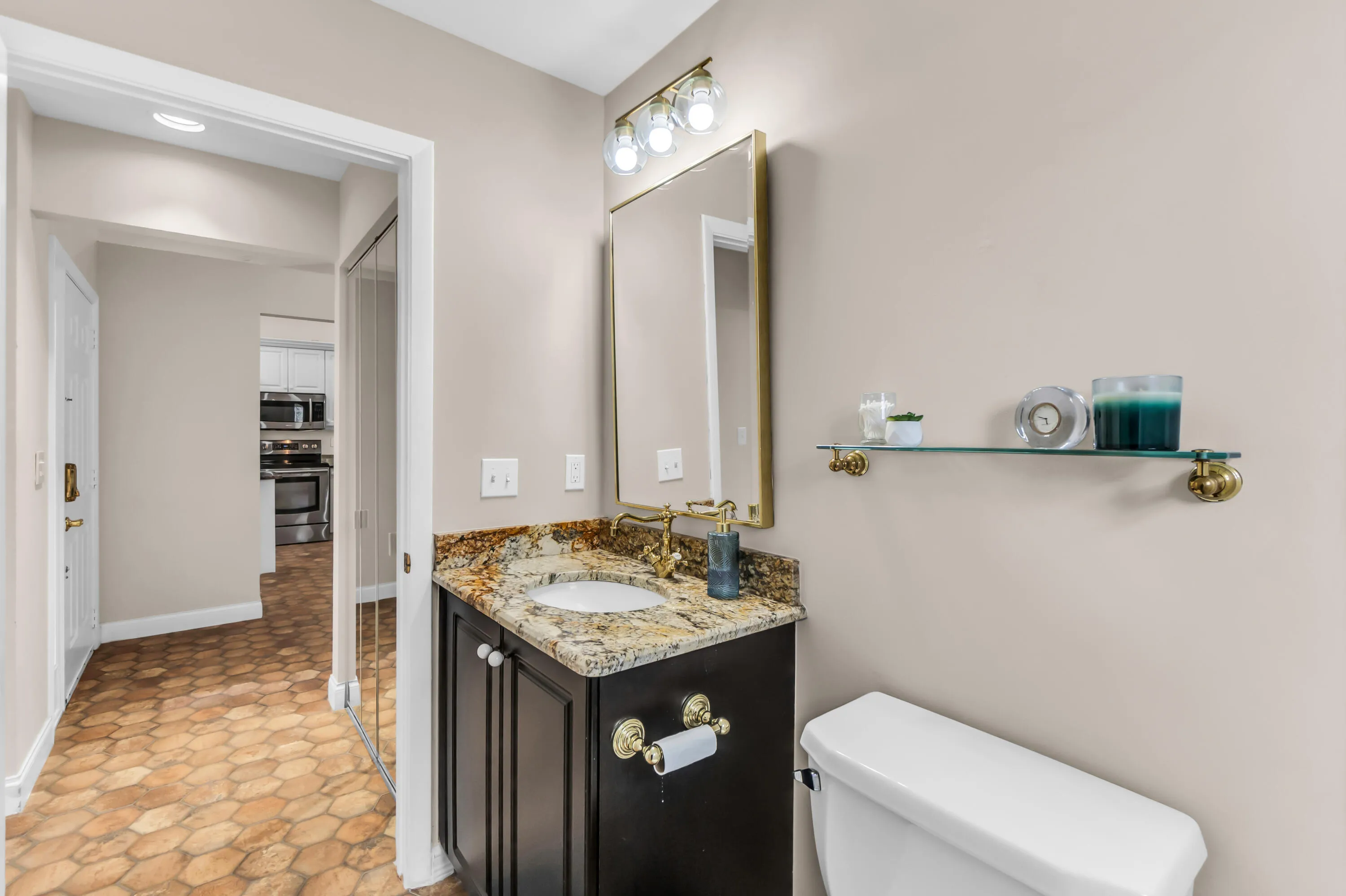 Bathroom featuring a dark wood vanity with a granite countertop and an undermount sink