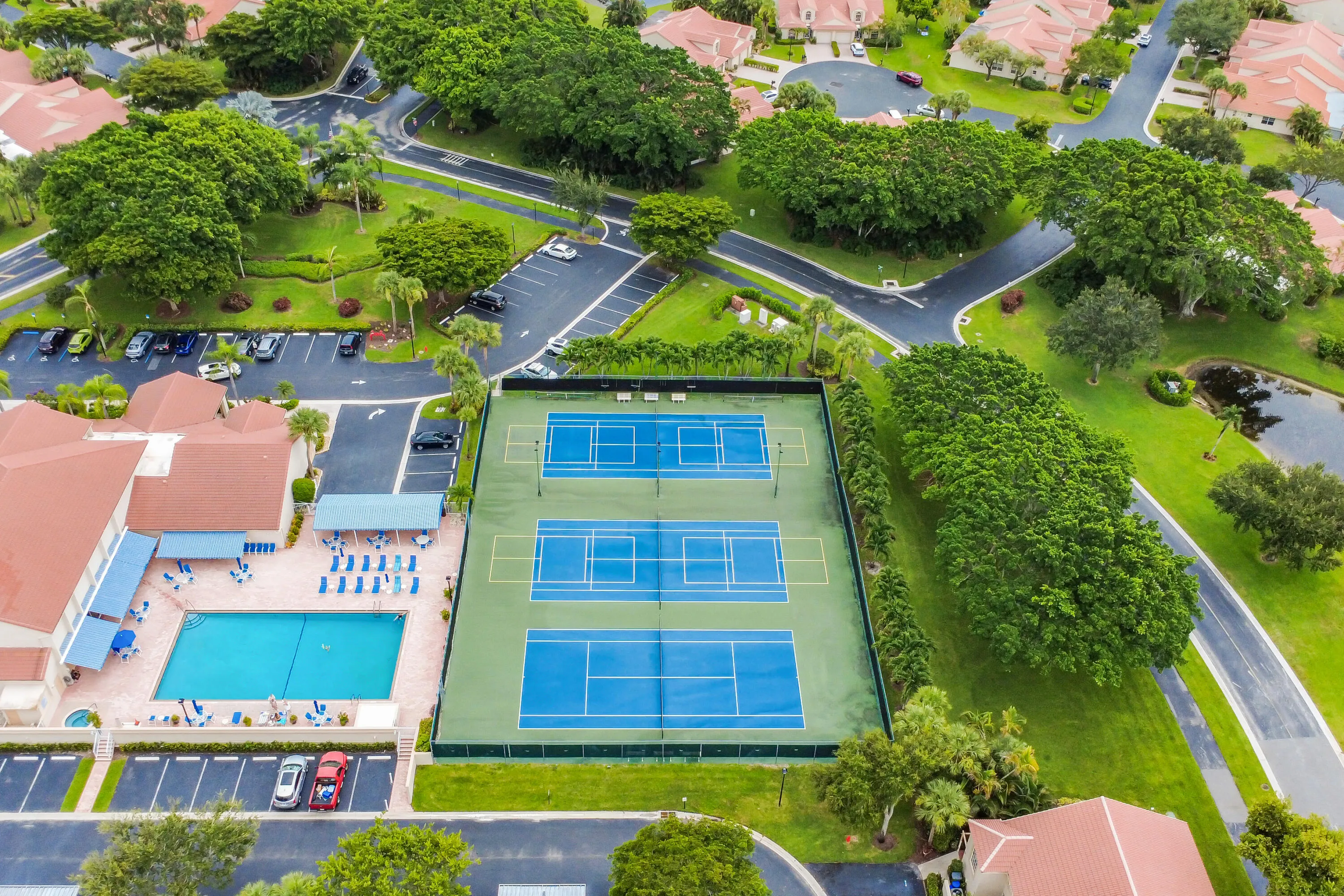 Community amenities featuring multiple tennis courts, a swimming pool, and a clubhouse structure