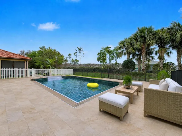 Outdoor swimming pool with integrated steps, surrounded by stone-look patio tiling