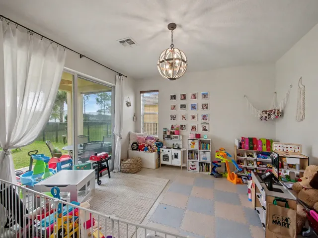Recessed lighting, sliding glass door, patio access, globe-style chandelier, and light wall finishes