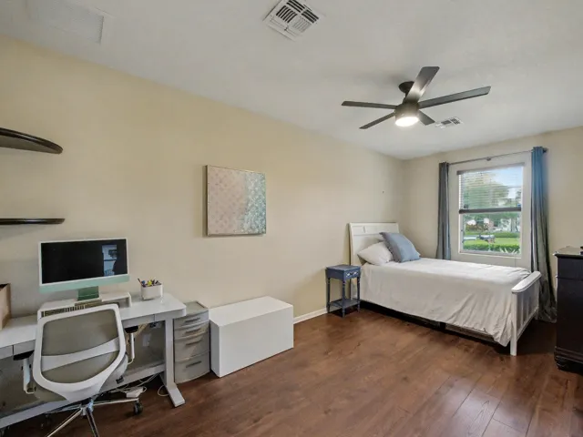 Wood-finish flooring throughout, with a window featuring blinds and drapes