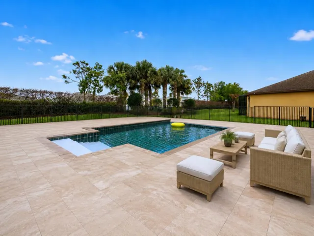 Swimming pool with tiled interior, integrated steps, and surrounding patio