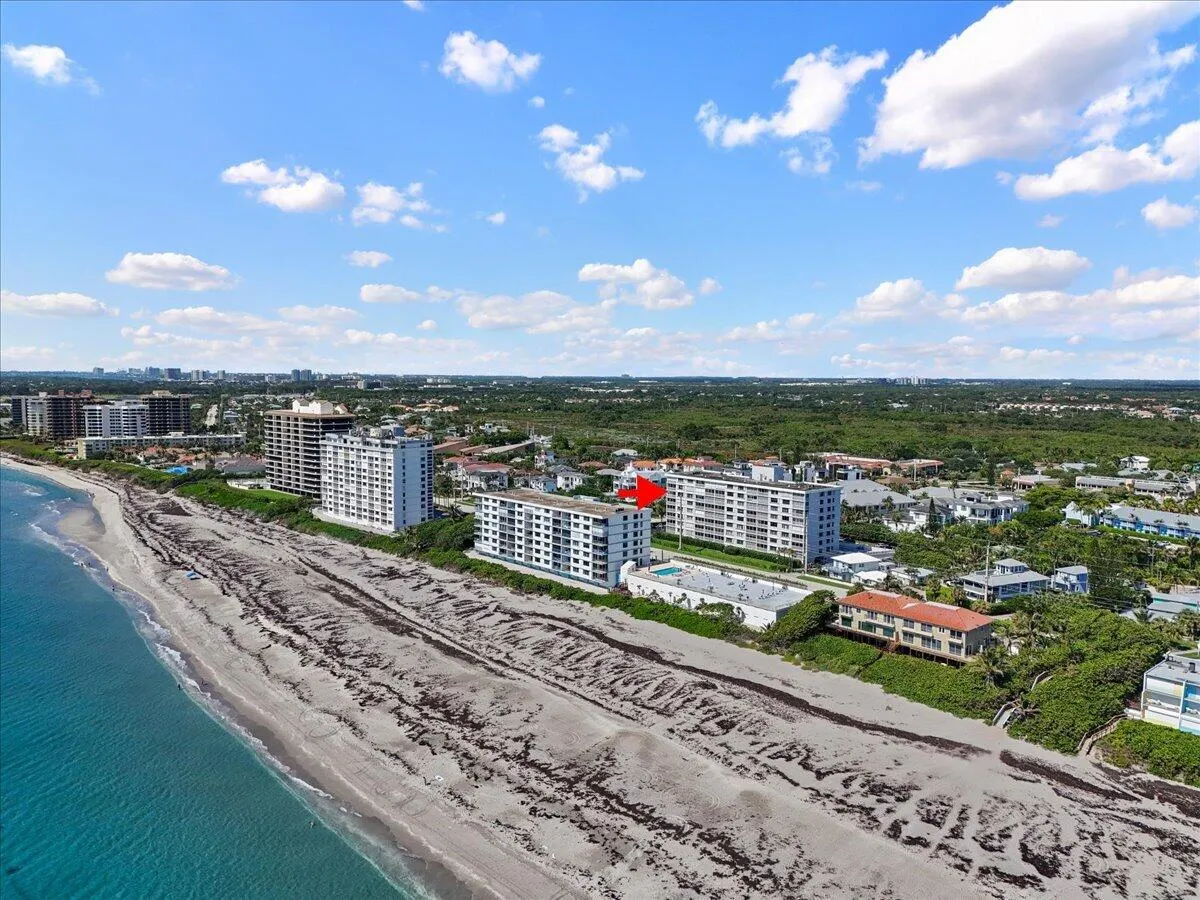 Coastal property with direct beach access, surrounded by multiple mid-rise buildings, and backed by extensive green space