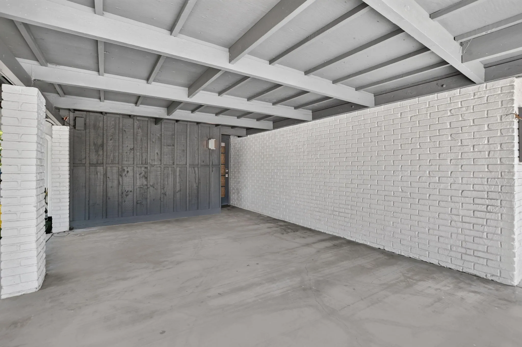 This oversized carport has plenty of room for a typical SUV with room to walk around the vehicle. It has lighting and an entrance door to the house. Perfect for rainy days!