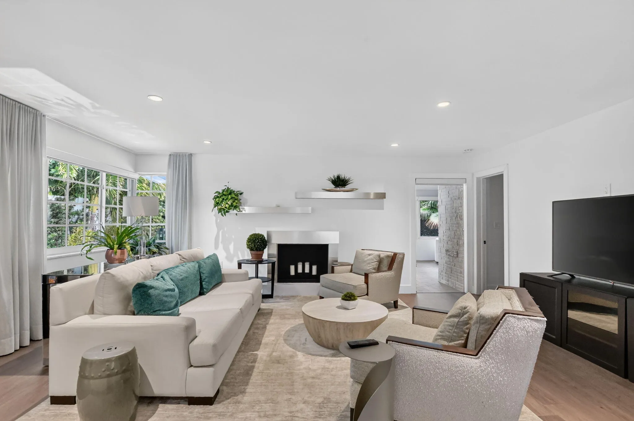 This spacious and bright family room (view from kitchen) has lots of widows ceiling lights on a dimmer, large wall for a Big screen TV with access to the Primary bedroom, sunroom and laundry room area and carport. This room has space for the whole family! Wonderful for NETFLIX binges!