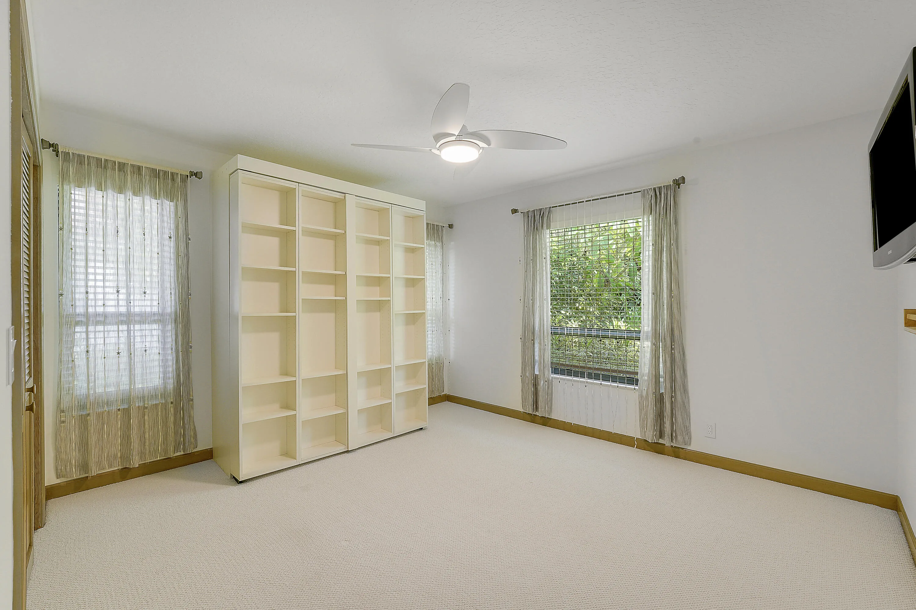 Versatile guestroom with new carpeting, featuring a built-in Murphy bed, perfect as a guest room, office, or multipurpose space.