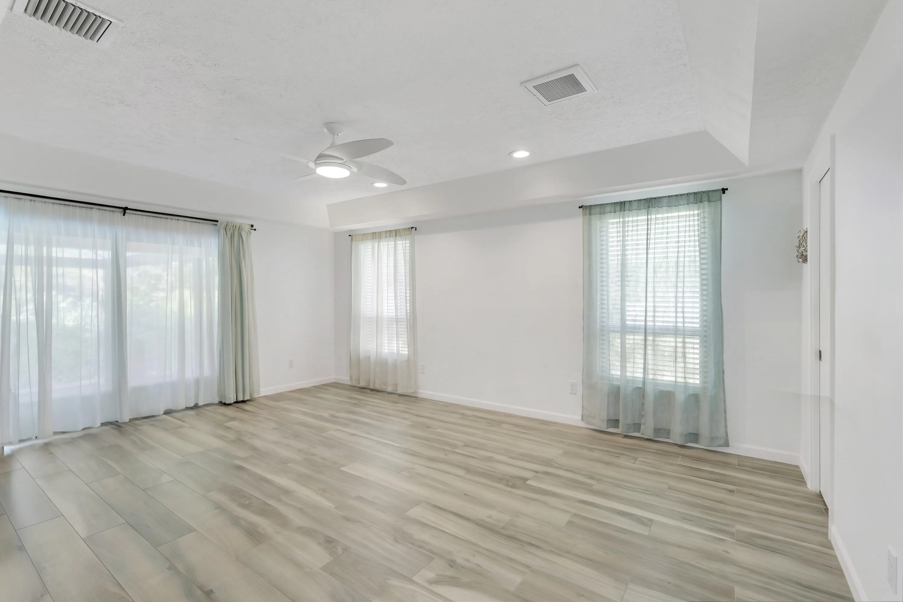 Large primary bedroom with slider to lanai and pool