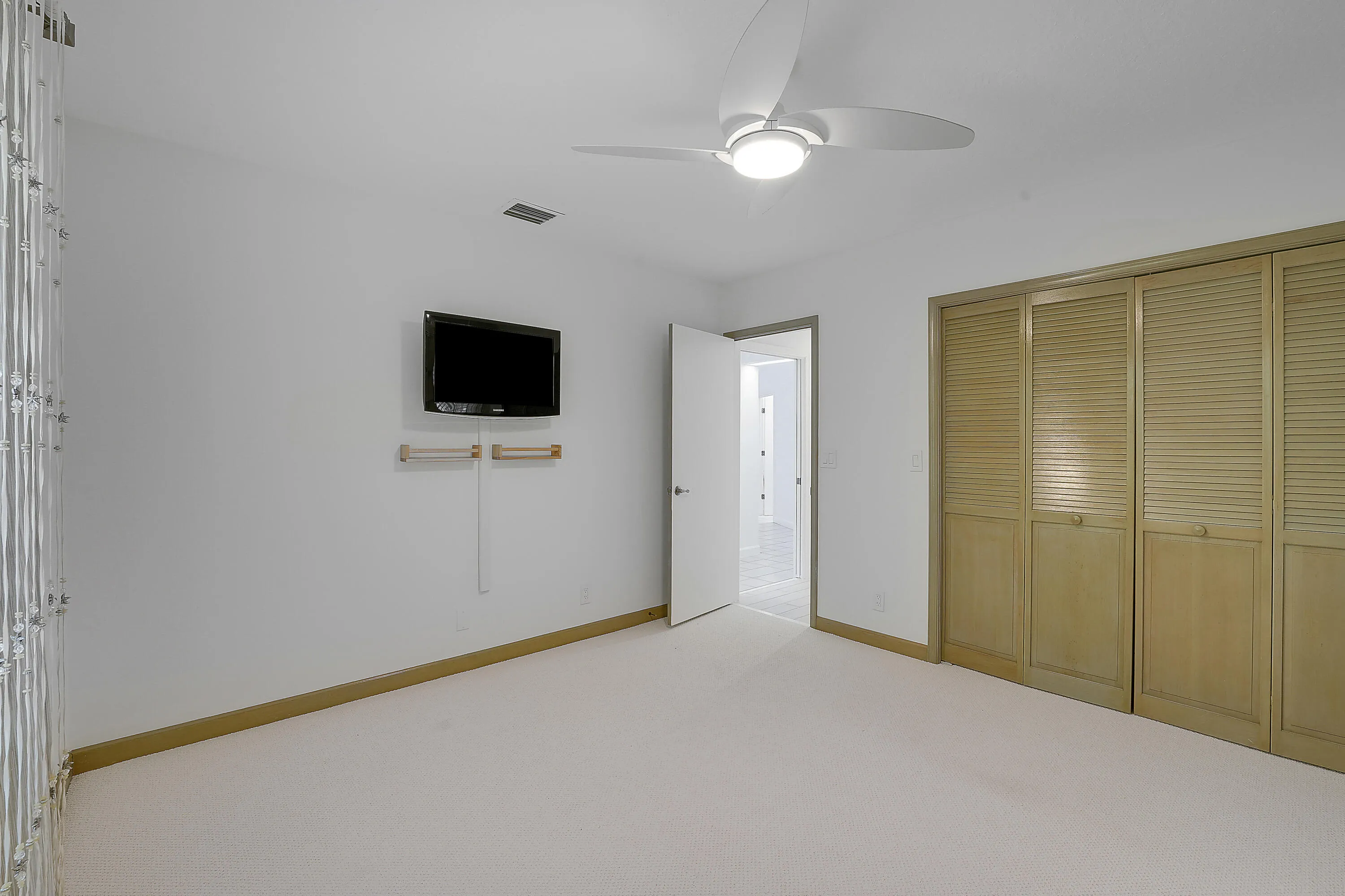 Versatile guestroom with new carpeting, featuring a built-in Murphy bed, Custom Elfa® Closet System, perfect as a guest room, office, or multipurpose space.