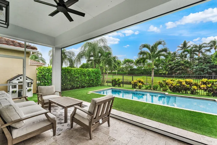 Patio and pool with travertine pavers and turf