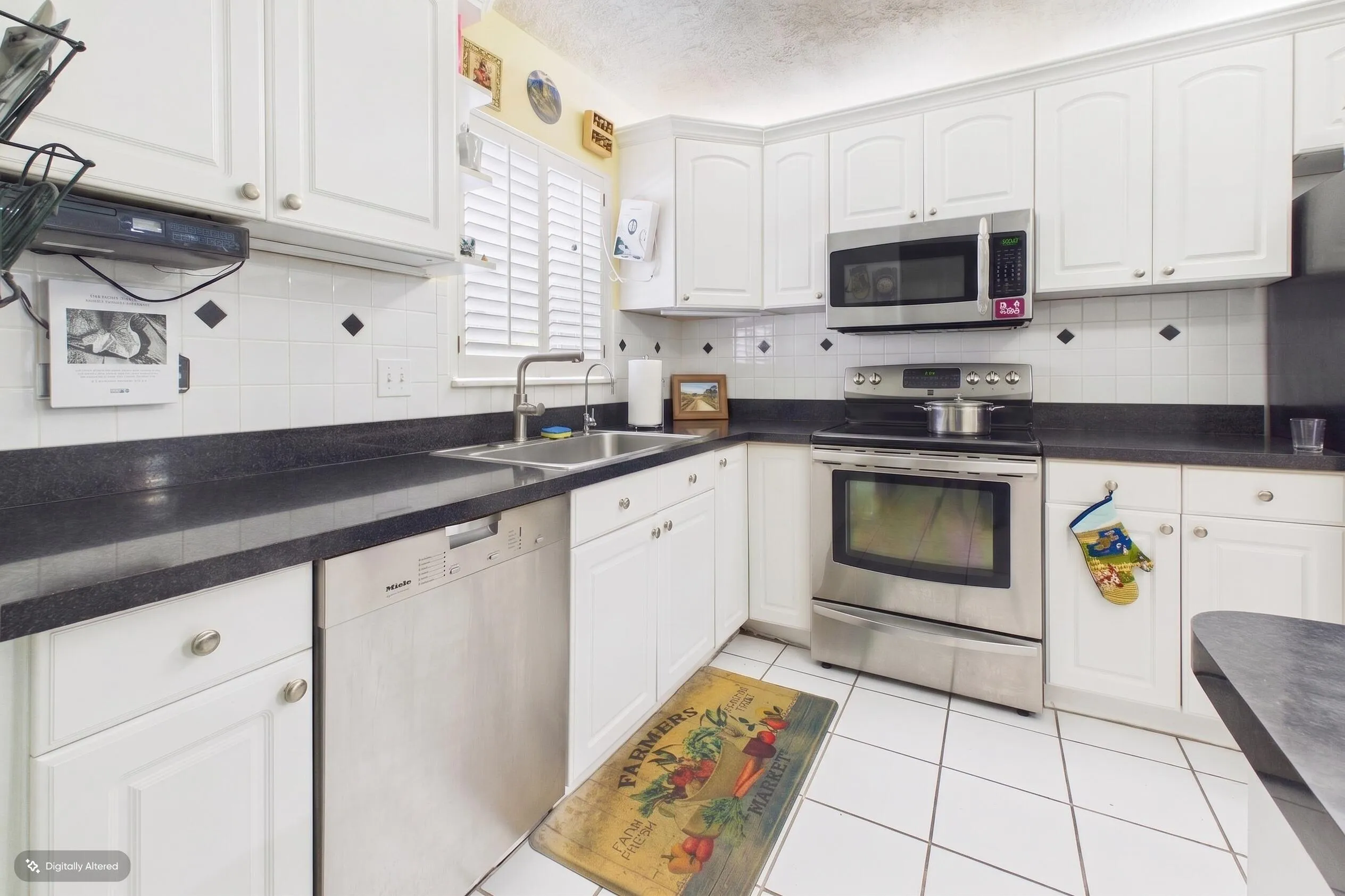Kitchen with stainless steel appliances: electric range, microwave, and dishwasher.