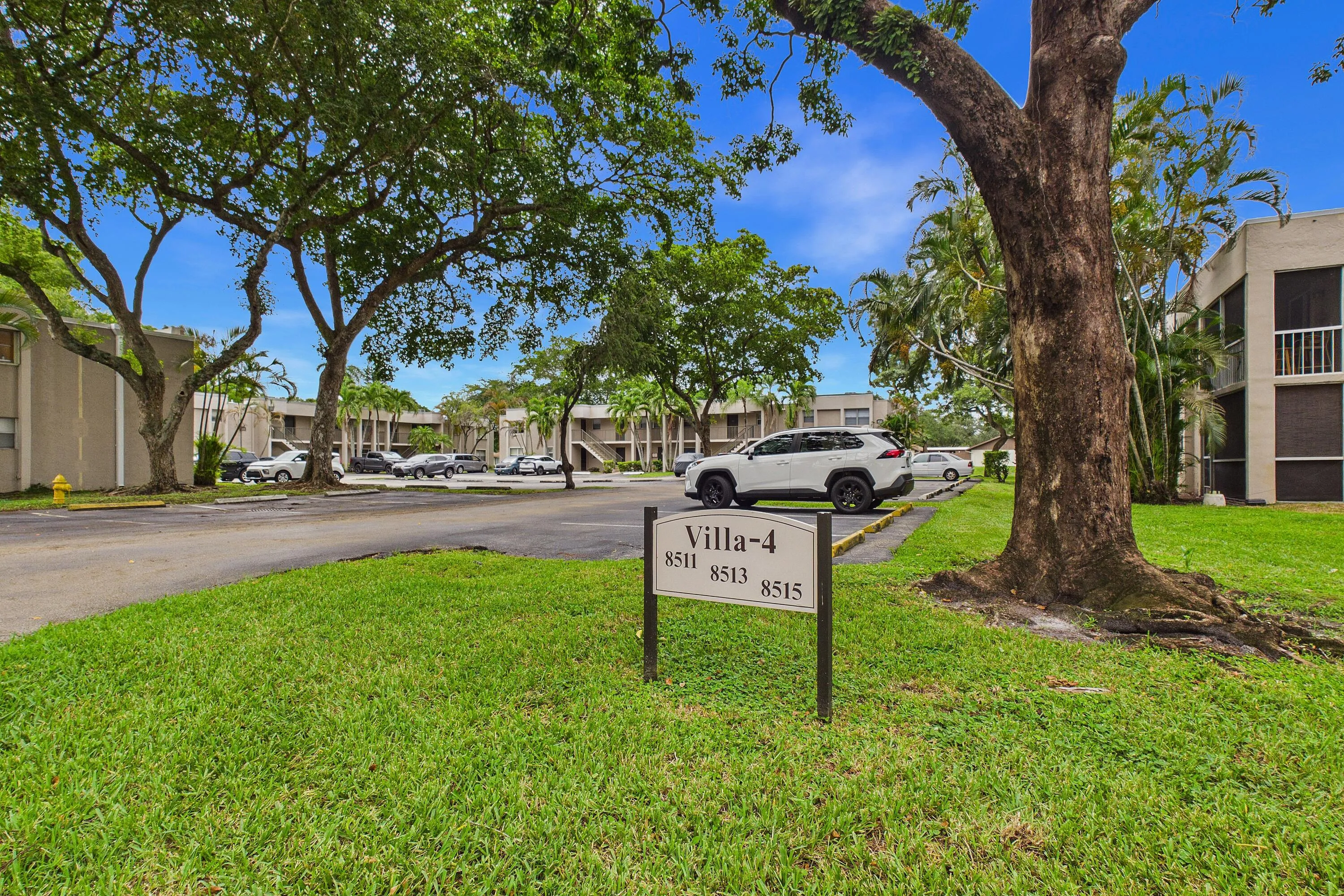 Manicured lawn with mature trees and a dedicated address marker