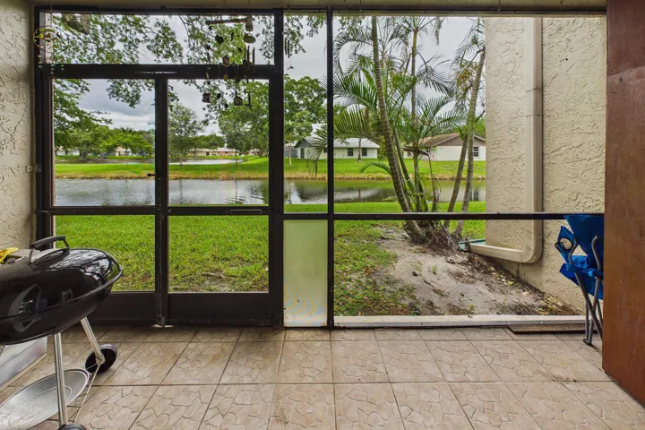 Screened-in patio with patterned tile flooring, offering a direct water frontage