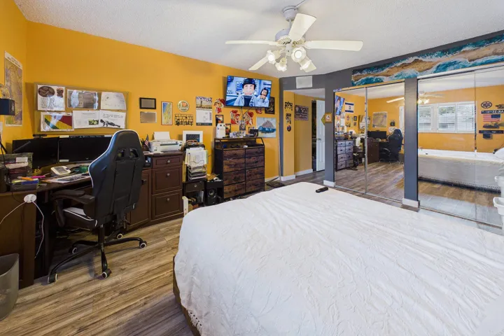Wood-finish flooring, ceiling fan, mirrored closet doors, and recessed lighting