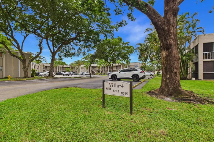 Manicured lawn with mature trees and a dedicated address marker