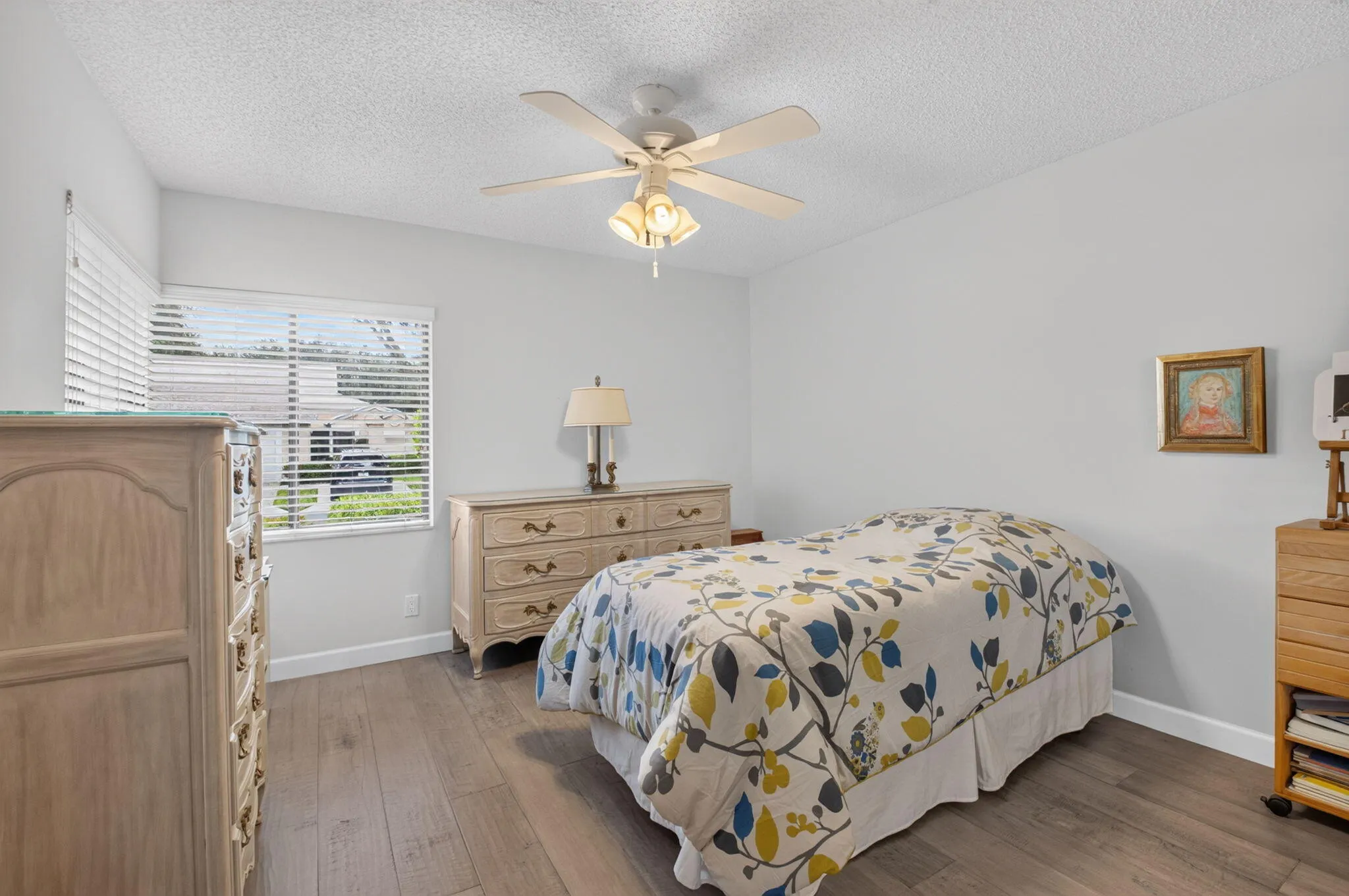 Vinyl flooring, white walls, window with horizontal blinds, and a ceiling fan with integrated lighting