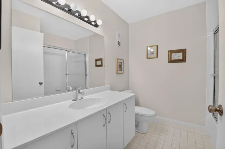 Vanity with integrated sink, chrome faucet, and expansive mirror