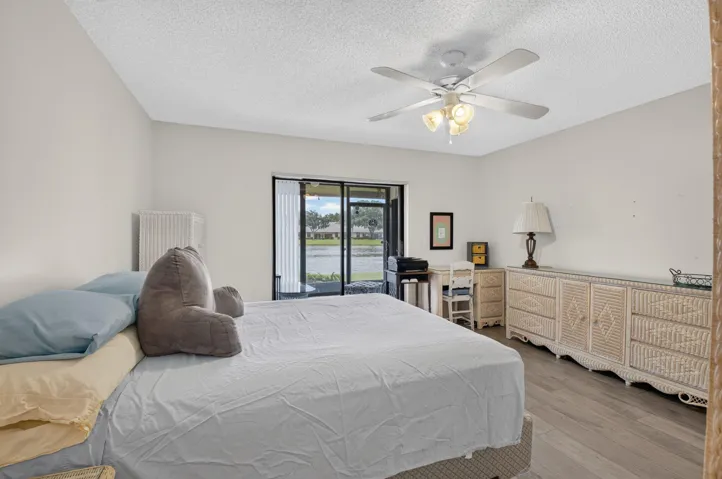 Sliding glass door, Vinyl flooring, ceiling fan with integrated lighting, and a neutral wall color