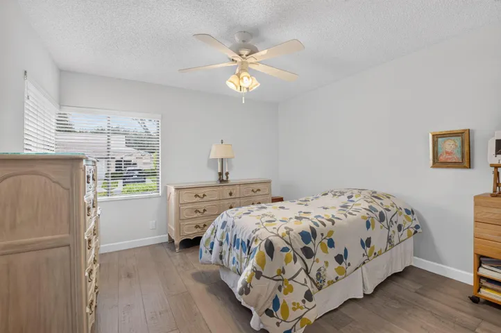 Vinyl flooring, white walls, window with horizontal blinds, and a ceiling fan with integrated lighting