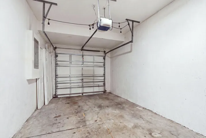 Garage with concrete flooring and an overhead door opener