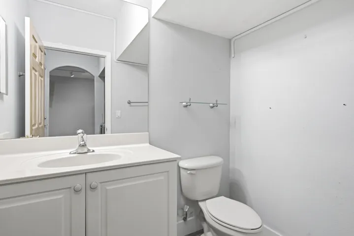 White vanity with recessed panel cabinet doors, integrated sink, and chrome faucet