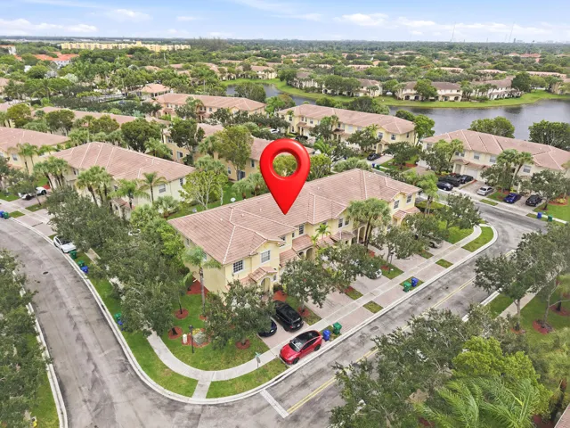 Townhome property featuring a tile roof and stucco exterior