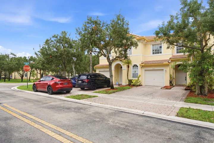 Stucco exterior with arched entryways, integrated garage, and a tile roof