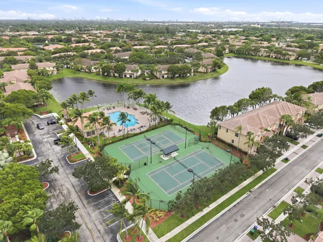 Community featuring a large central lake, multiple tennis courts, and an outdoor swimming pool with surrounding lounge areas