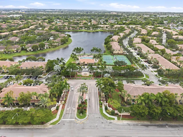 Lakeside community featuring extensive landscaping, a tennis court, a swimming pool, and a central water feature