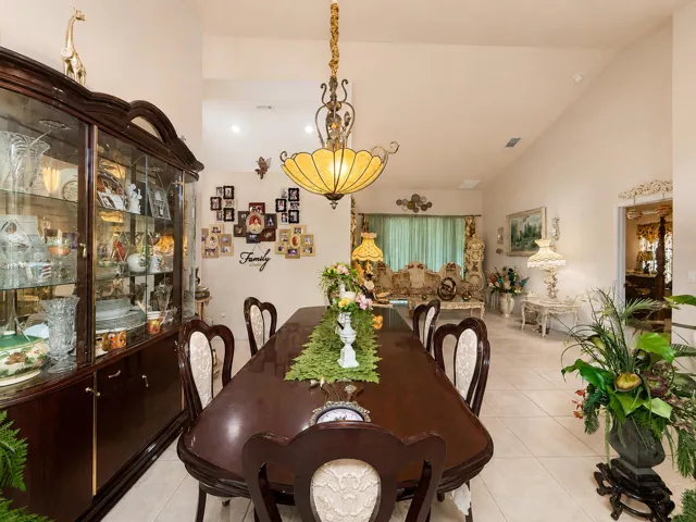 Vaulted ceilings, a built-in display cabinet, and tile flooring define this dining area