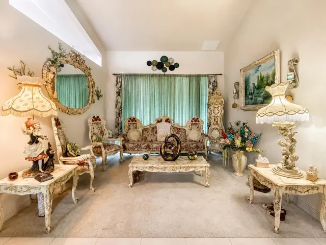 Wall-to-wall carpeting, decorative wall mirror, patterned window treatments, and sconce lighting