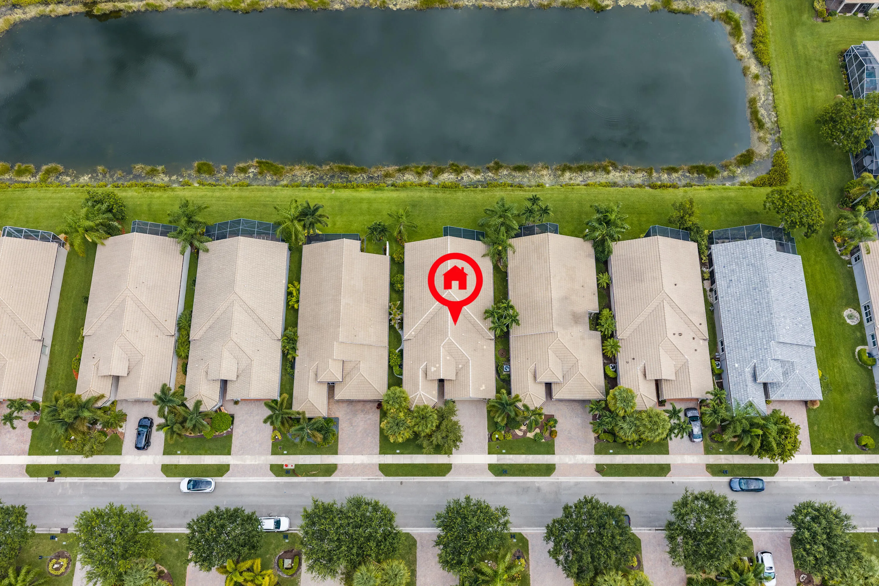 Aerial perspective showcases the home's desirable lakefront setting within beautifully landscaped Valencia Shores.