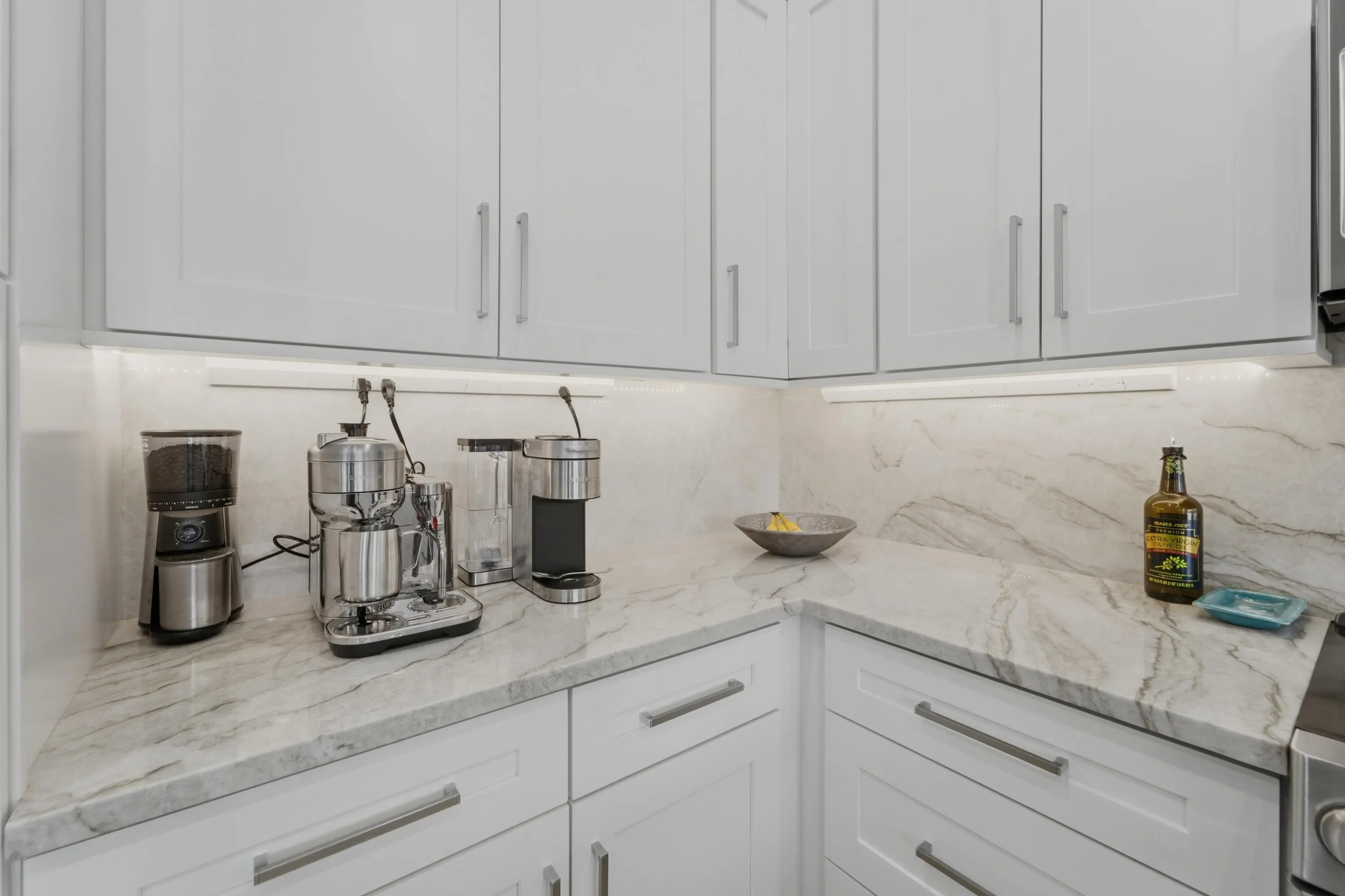 Generous countertop space, dedicated appliance storage and under-cabinet lighting add both function and polish to the renovated kitchen.
