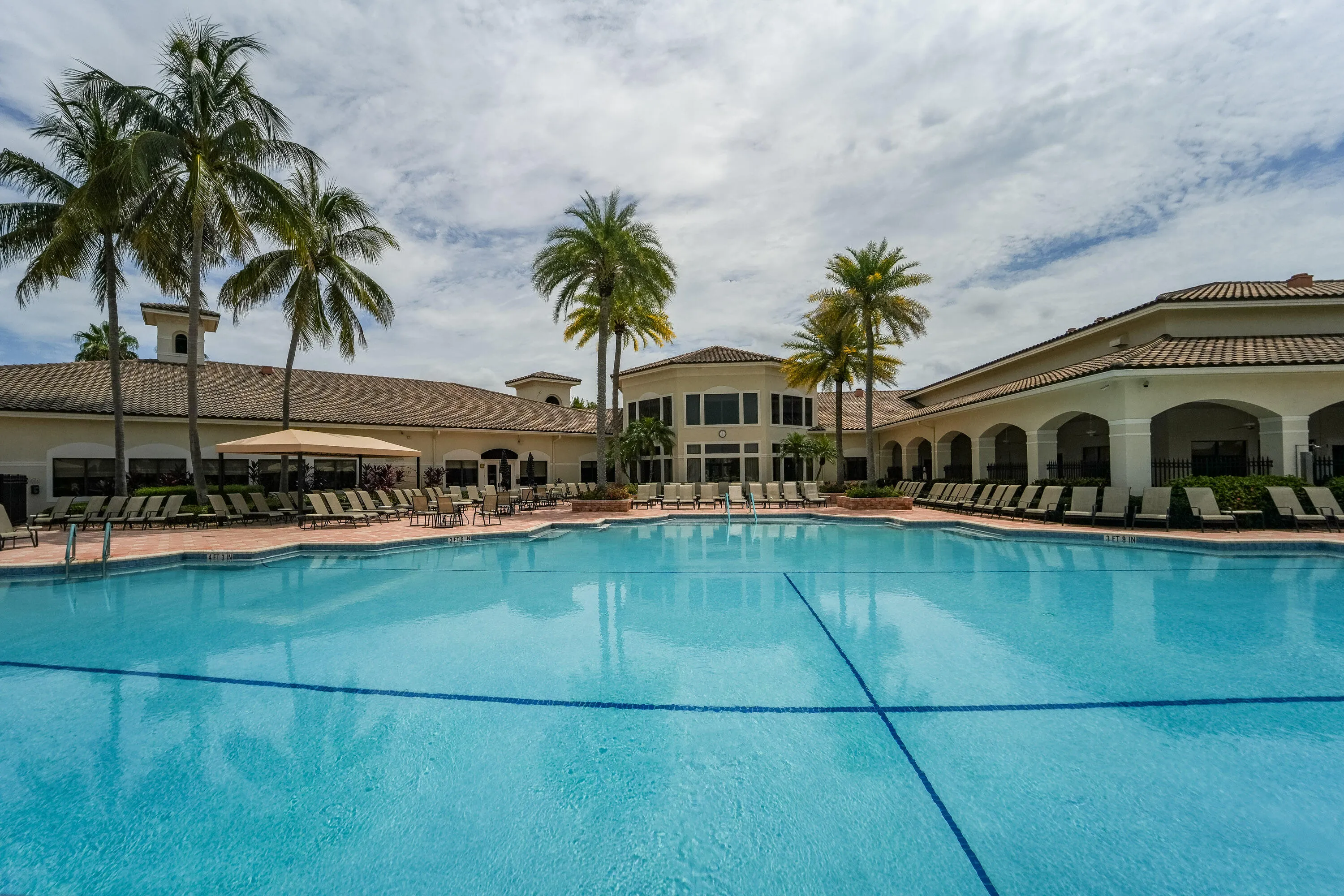 Resort-style Social Club pool is surrounded by generous deck space and shaded seating for relaxed Florida living.
