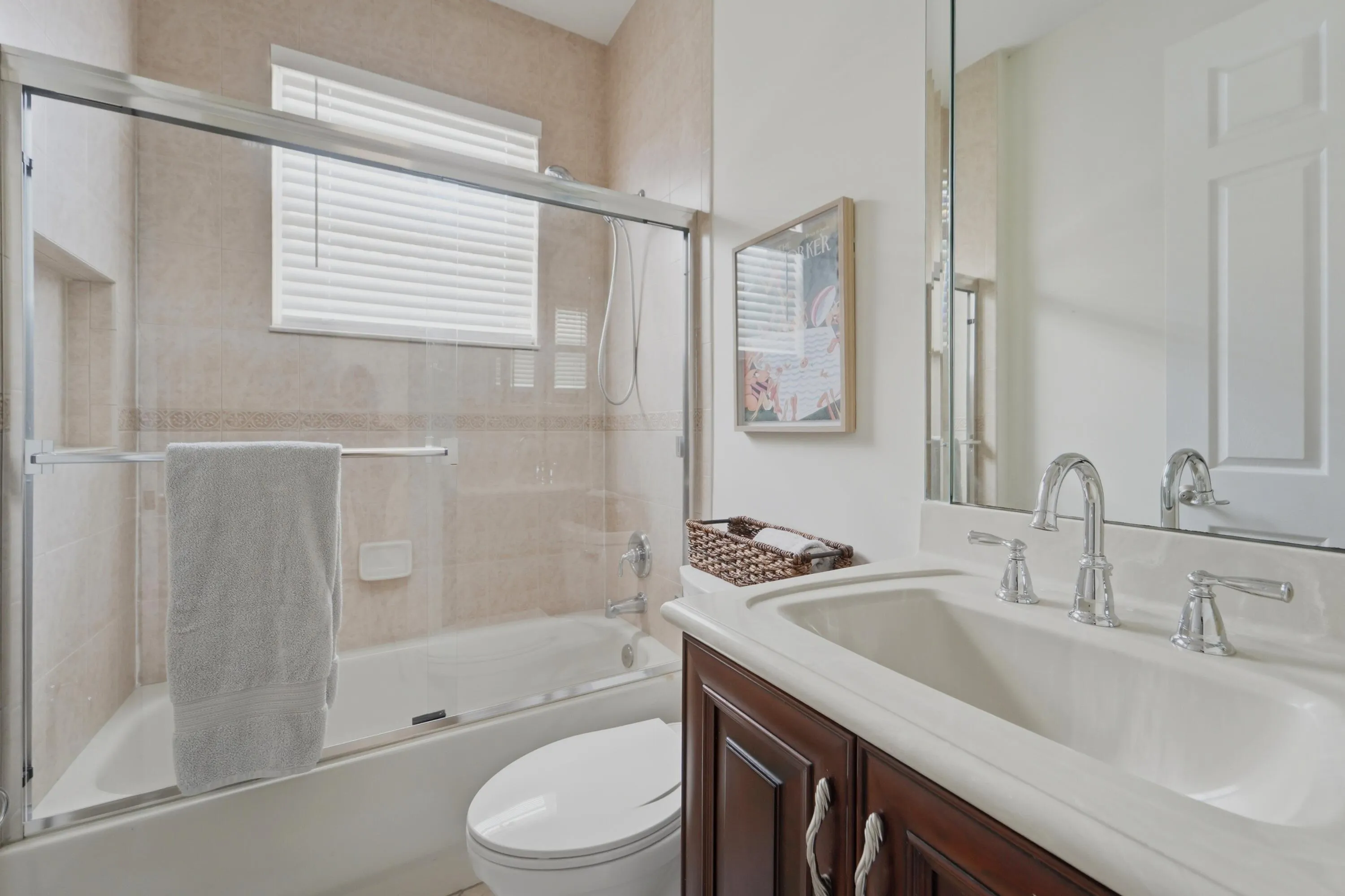 Guest bath offers a tub/shower combination, vanity storage and a bright, neutral finish.