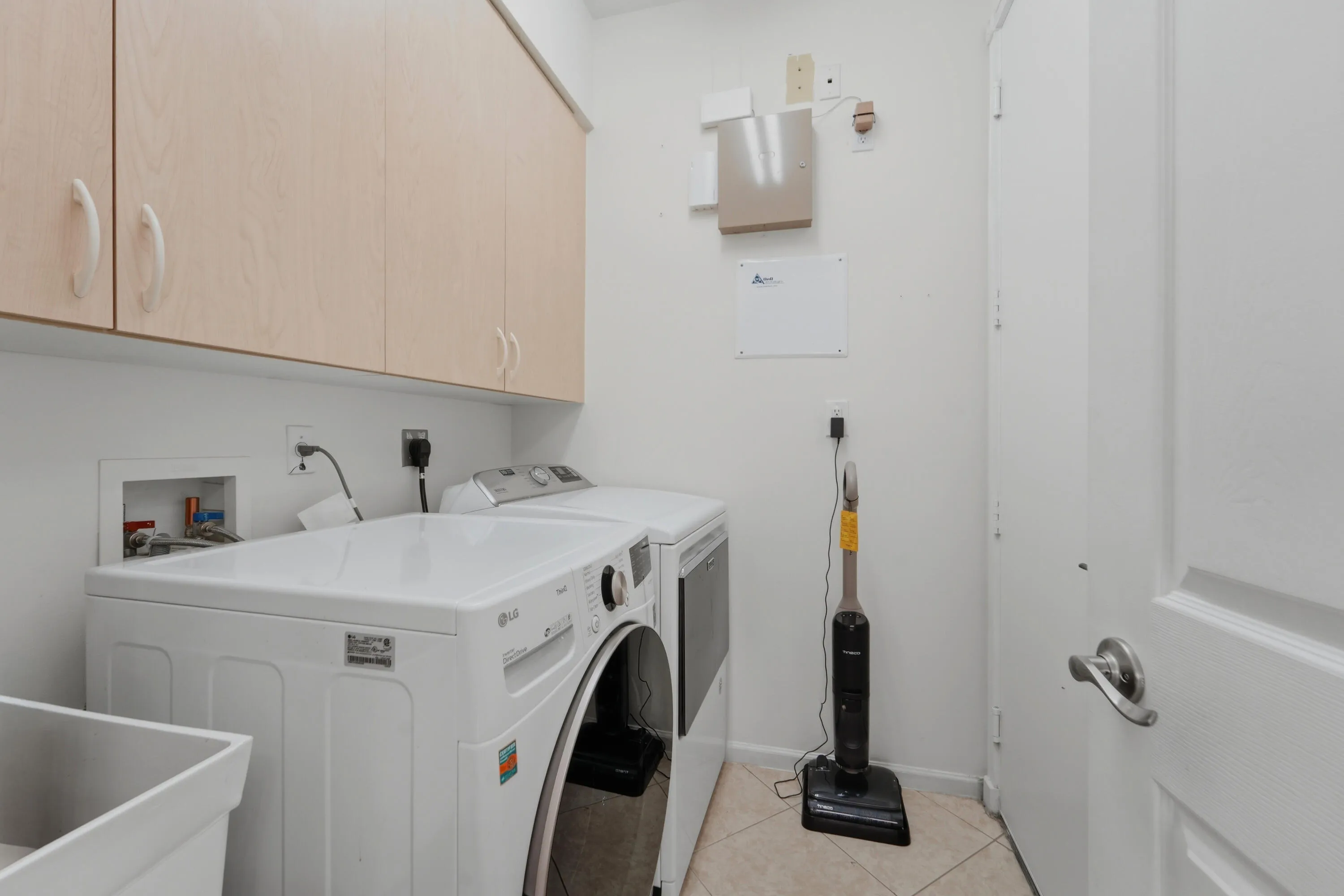 Laundry room with Full Size Washer & Dryer, laundry sink, and cabinetry for convenient storage and everyday organization.