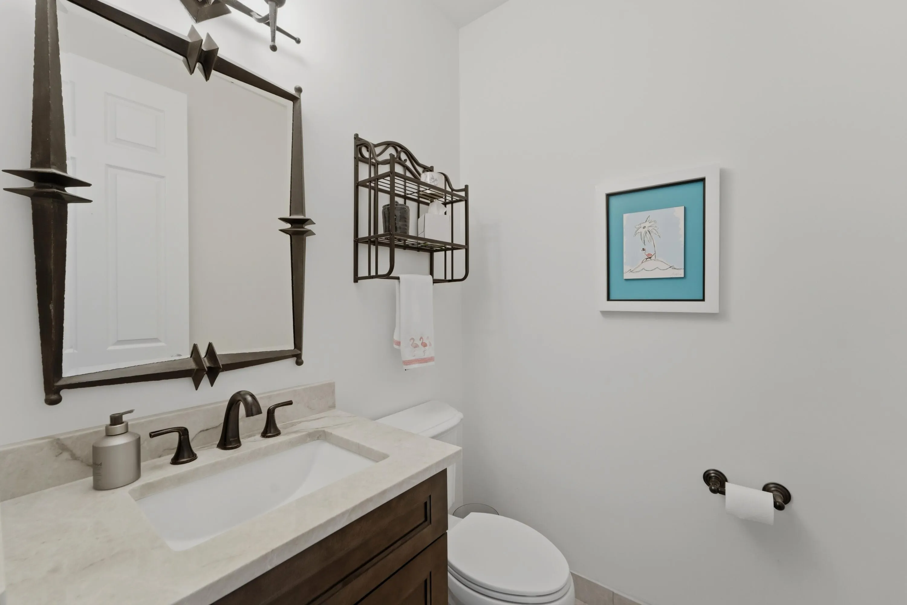 Convenient powder room features a stylish vanity, framed mirror and polished finishes for guests.