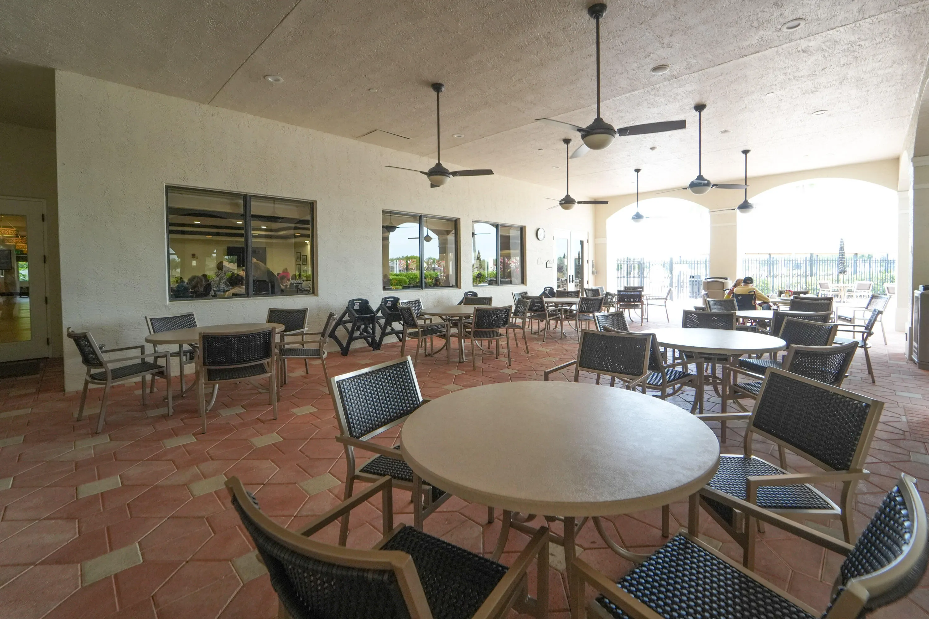 Covered outdoor seating extends the Social Club lifestyle outdoors with space to relax and socialize near the lake.