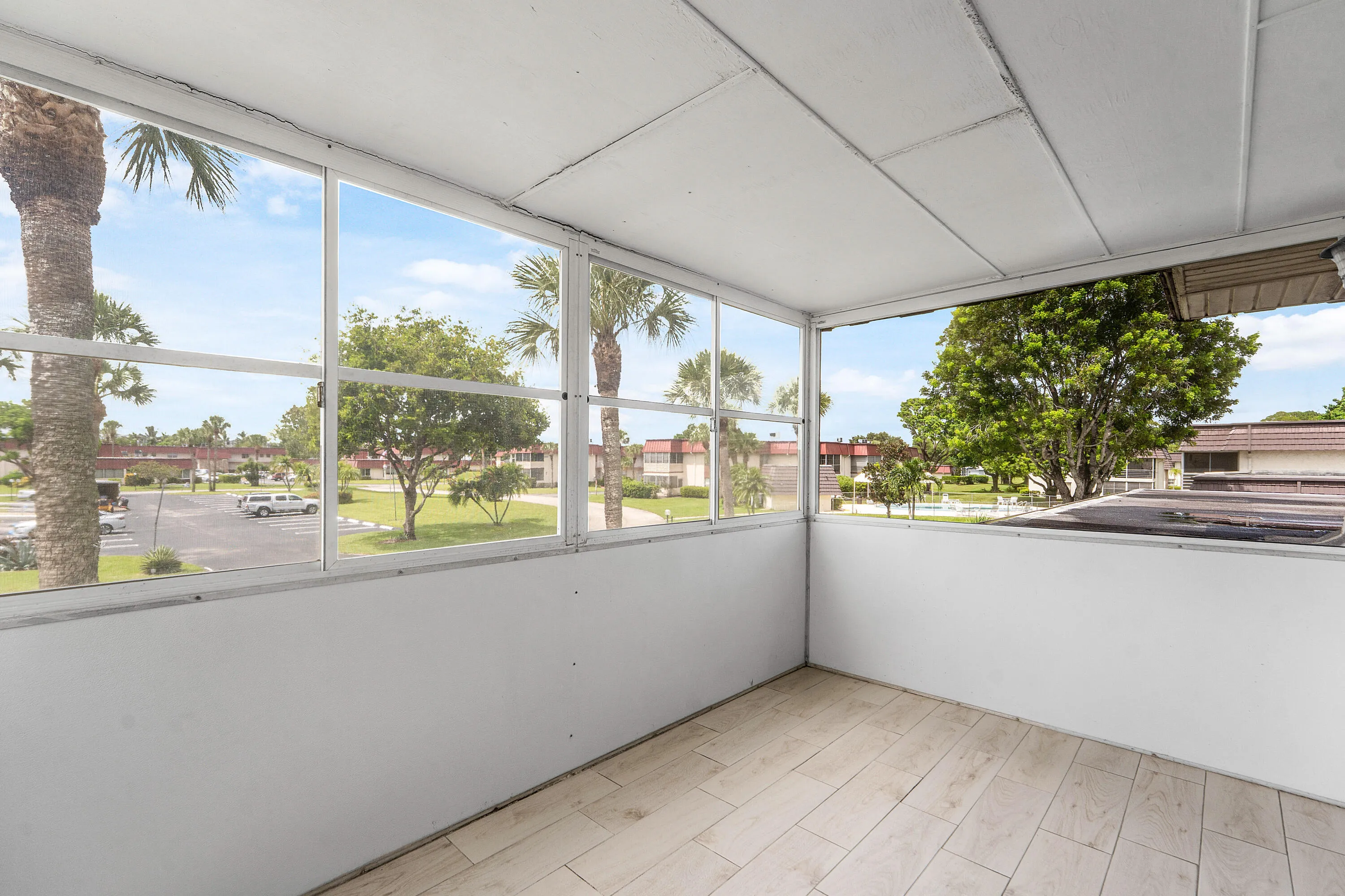 Screened-in patio featuring tile flooring and expansive exterior views