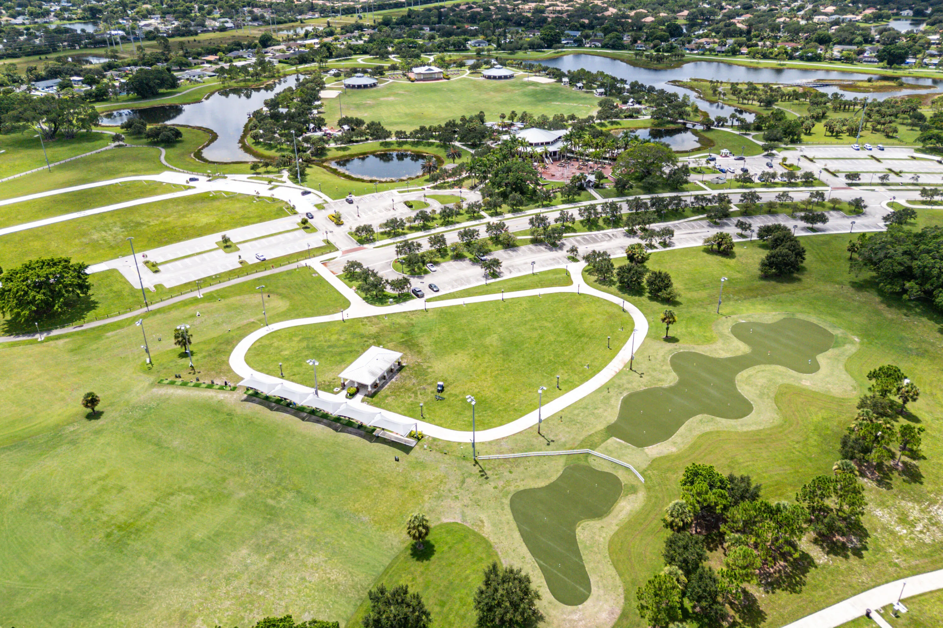 Expansive green spaces featuring walking paths, multiple parking areas, and mature landscaping
