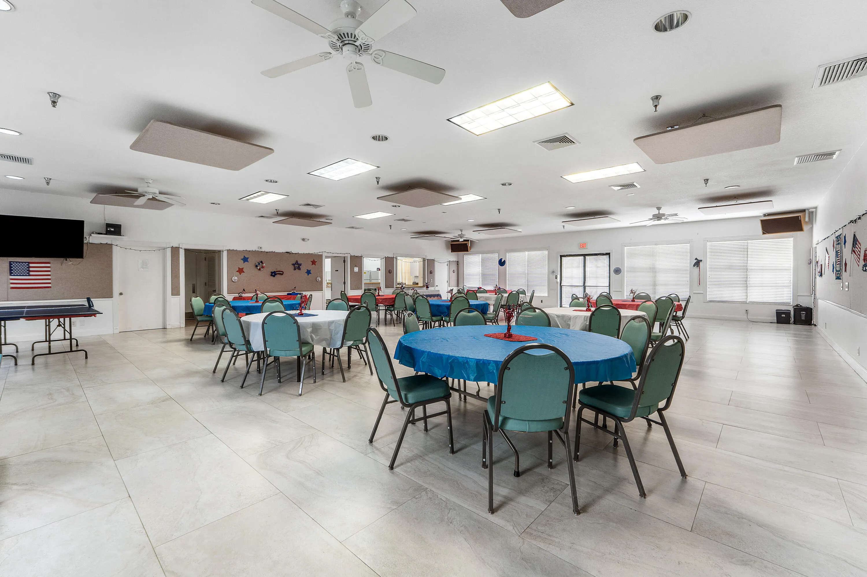 Spacious room featuring tile flooring, ceiling fans, recessed lighting, and multiple windows with blinds
