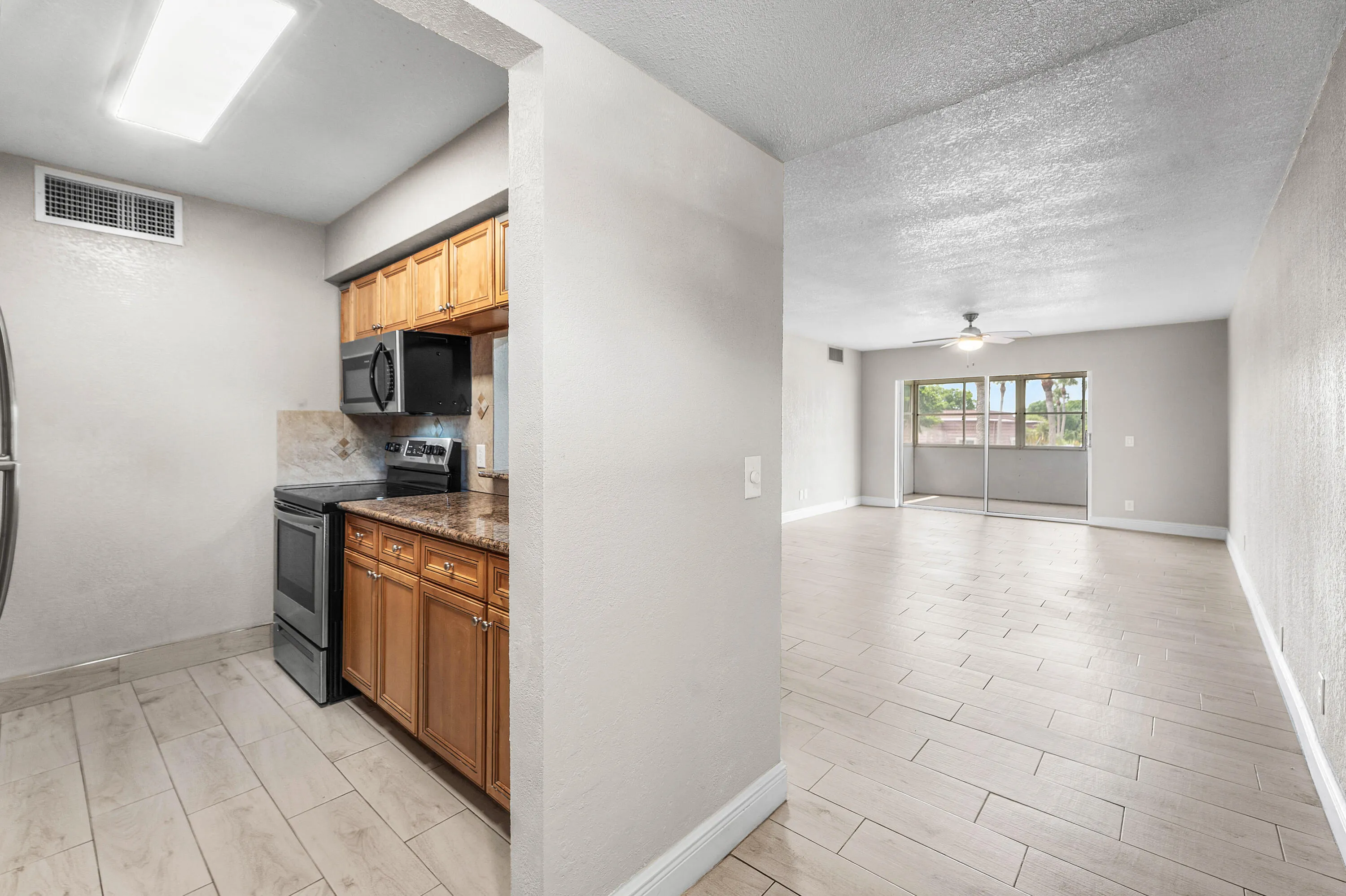 Kitchen with wood-finish cabinetry, stone countertop, and stainless steel appliances